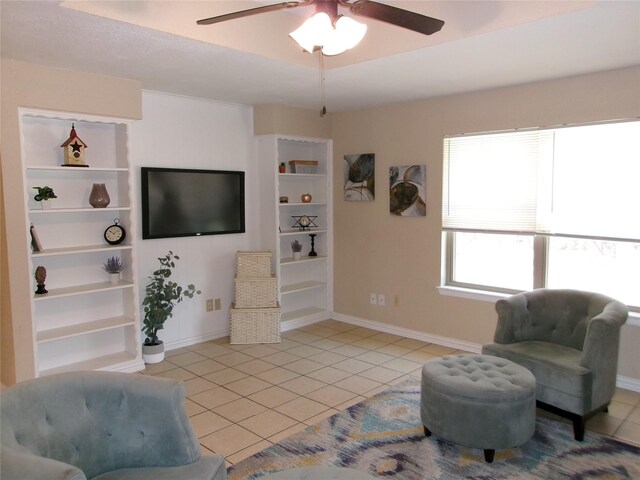 sitting room with light tile patterned floors, built in features, and ceiling fan