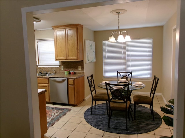 dining space featuring a chandelier, sink, and light tile patterned flooring