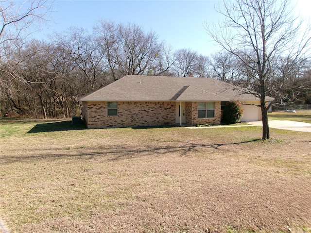 view of front facade with a garage, central AC, and a front lawn