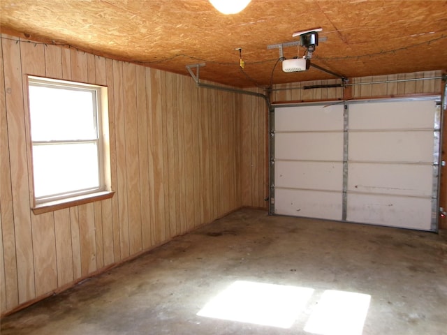 garage featuring a garage door opener and wood walls