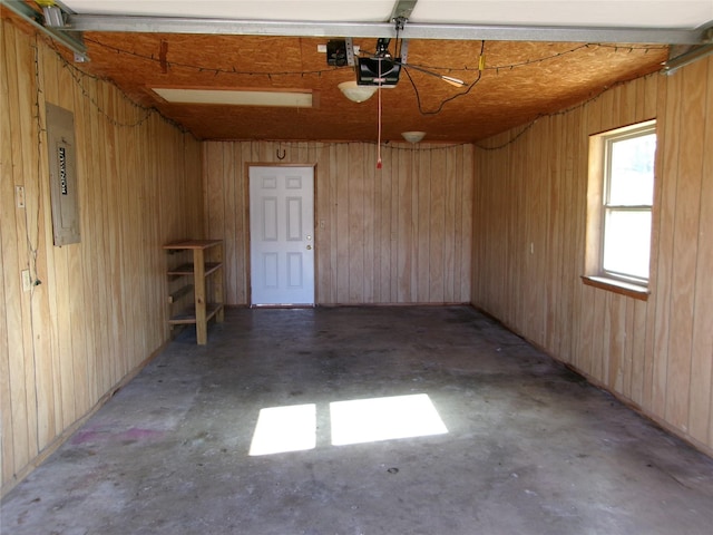 garage with electric panel and wood walls