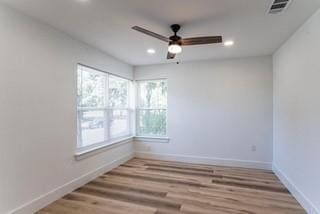 spare room with ceiling fan, a healthy amount of sunlight, and wood-type flooring