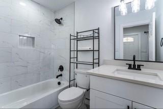 full bathroom with tiled shower / bath combo, toilet, and vanity