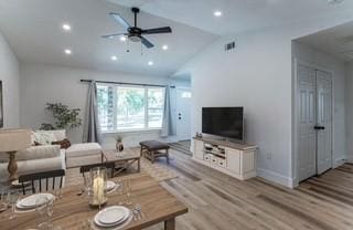 living room featuring ceiling fan, light hardwood / wood-style floors, and lofted ceiling