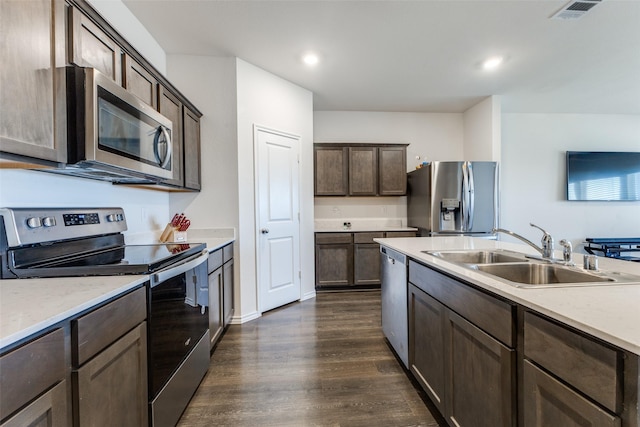 kitchen with dark brown cabinets, dark hardwood / wood-style flooring, stainless steel appliances, and sink