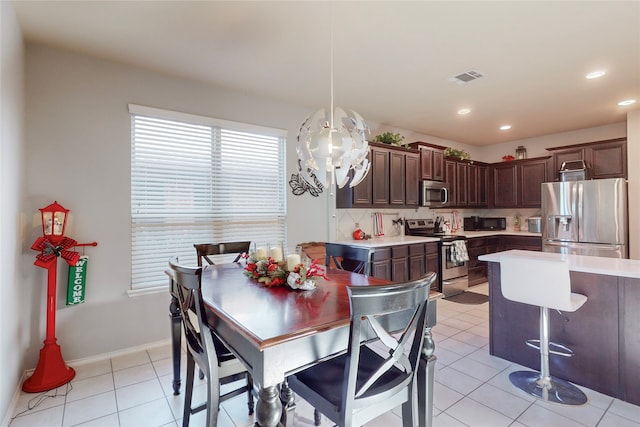 dining area featuring light tile patterned floors and an inviting chandelier