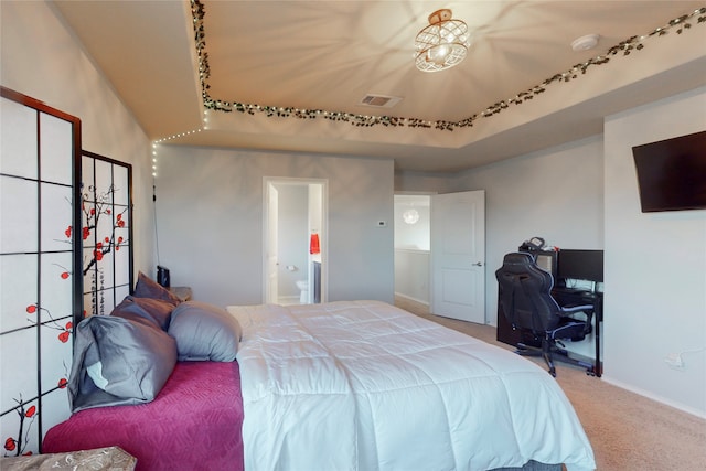 bedroom with ensuite bath and carpet flooring