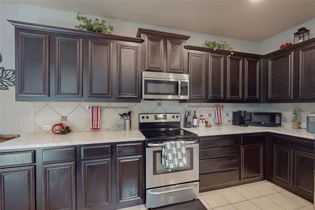 kitchen featuring tasteful backsplash, light tile patterned floors, dark brown cabinets, and appliances with stainless steel finishes