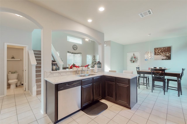 kitchen featuring light tile patterned flooring, stainless steel dishwasher, sink, and dark brown cabinets