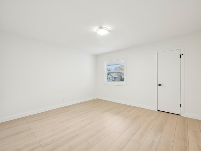 spare room with light wood-style flooring and baseboards