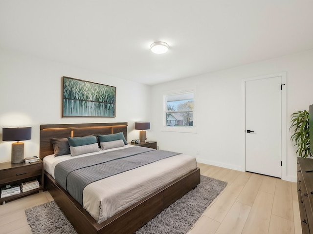 bedroom with light wood-type flooring and baseboards