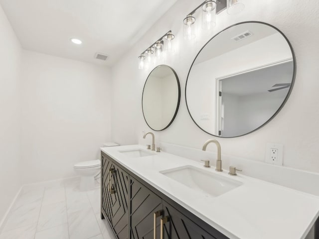 full bathroom with visible vents, a sink, toilet, and double vanity