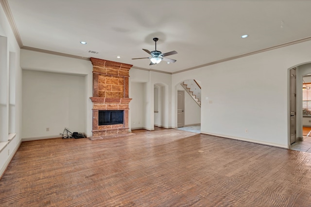 unfurnished living room with a fireplace, ceiling fan, and ornamental molding