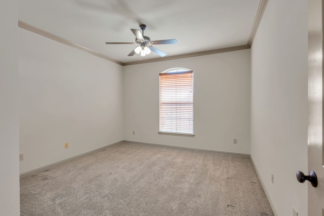 empty room with light carpet, ornamental molding, a ceiling fan, and baseboards