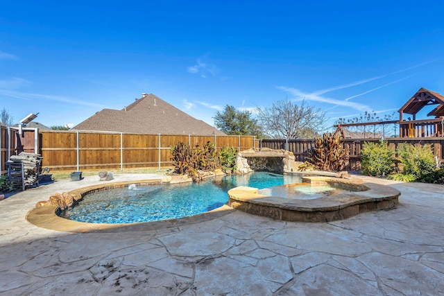 view of swimming pool featuring pool water feature, an in ground hot tub, and a patio