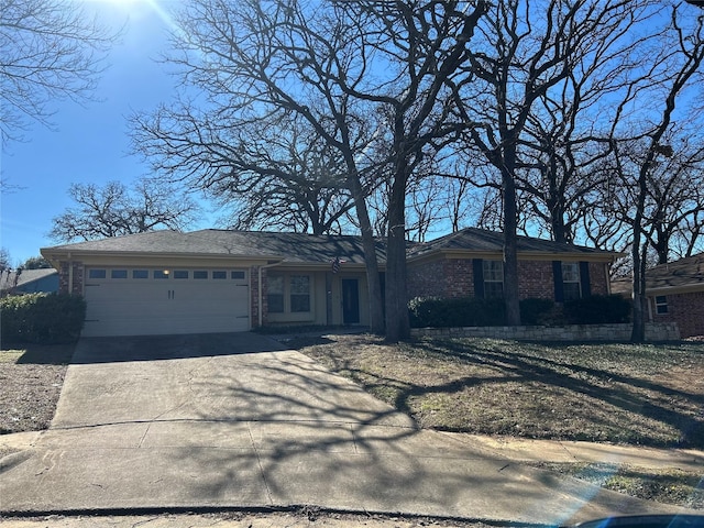 view of front of home featuring an attached garage, driveway, and brick siding