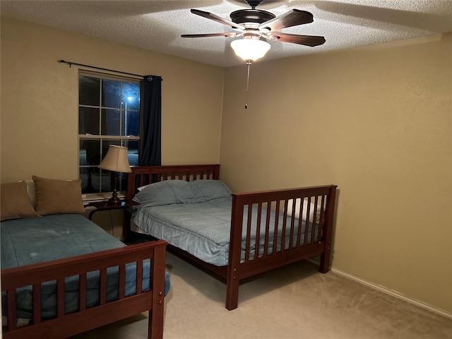 bedroom featuring a textured ceiling, baseboards, a ceiling fan, and light colored carpet