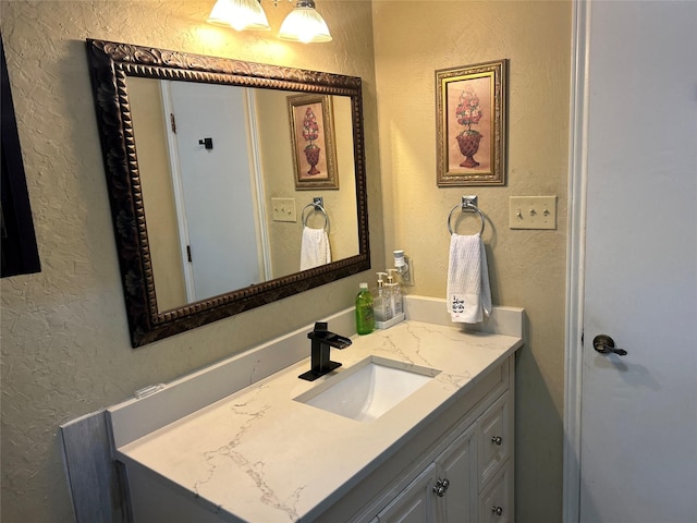 bathroom with vanity and a textured wall