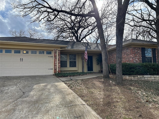 ranch-style home featuring concrete driveway, brick siding, and an attached garage