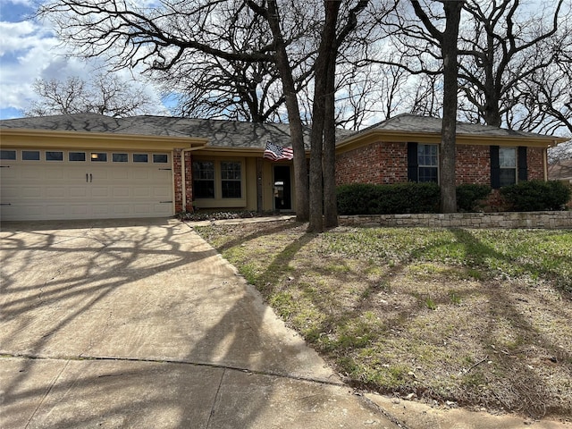 single story home with brick siding, concrete driveway, and an attached garage