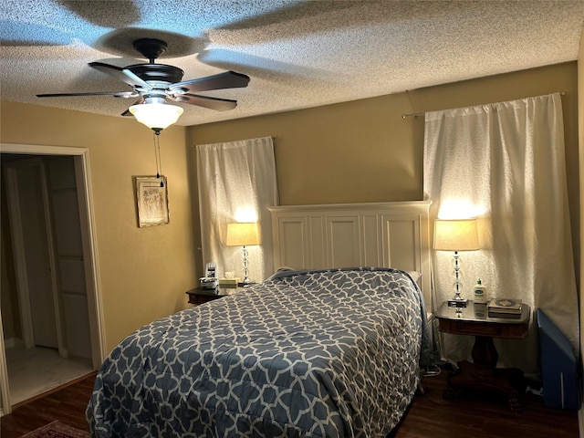 bedroom with dark wood-style flooring, ceiling fan, and a textured ceiling