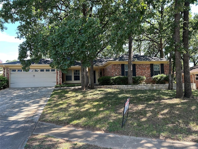 ranch-style home featuring a garage, a front yard, concrete driveway, and brick siding