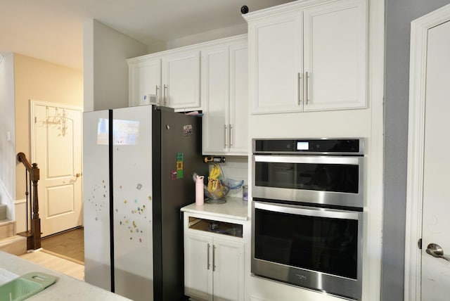 kitchen with white cabinetry, stainless steel appliances, and light wood-type flooring