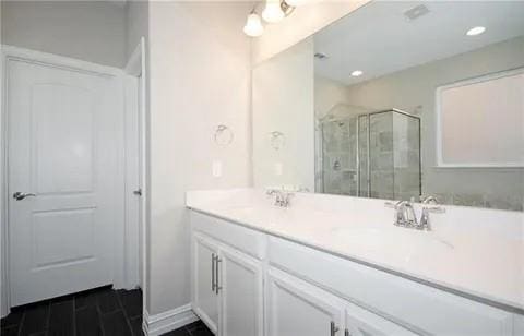 bathroom with vanity and a shower with shower door