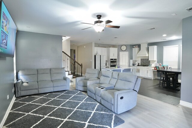 living room featuring hardwood / wood-style floors and ceiling fan