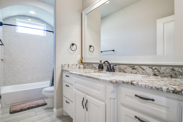 full bathroom featuring tiled shower / bath combo, vanity, and toilet