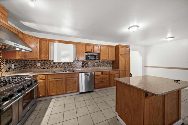 kitchen featuring sink, wall chimney range hood, a breakfast bar, light tile patterned flooring, and appliances with stainless steel finishes