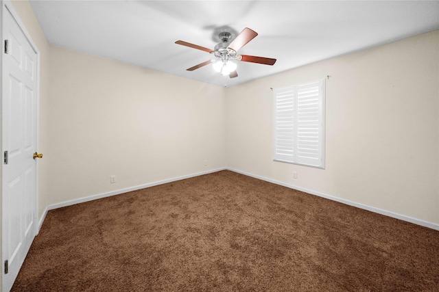 spare room featuring ceiling fan and dark carpet