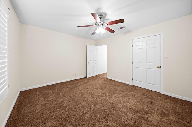 unfurnished bedroom with dark colored carpet, a closet, and ceiling fan