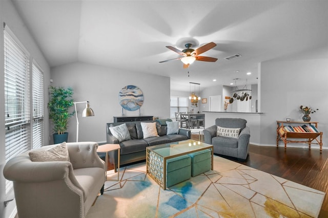 living room with lofted ceiling, ceiling fan with notable chandelier, and light hardwood / wood-style flooring