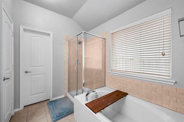 bathroom with tile patterned flooring, vaulted ceiling, and separate shower and tub