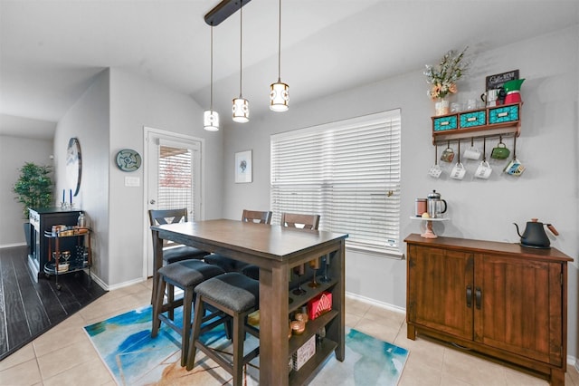 tiled dining space featuring lofted ceiling