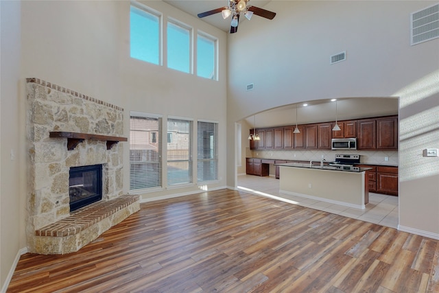 unfurnished living room featuring ceiling fan, visible vents, and light wood-style flooring