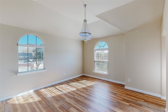 unfurnished room featuring light hardwood / wood-style flooring and an inviting chandelier