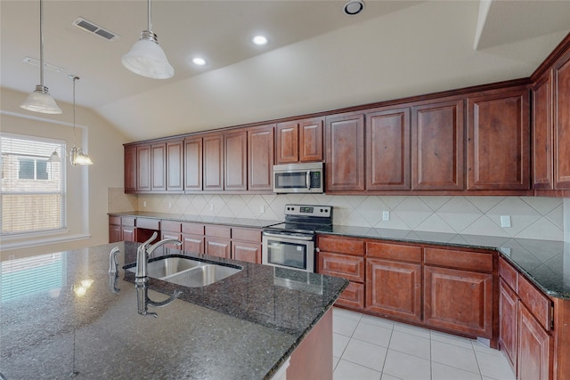 kitchen with backsplash, dark stone countertops, decorative light fixtures, vaulted ceiling, and appliances with stainless steel finishes