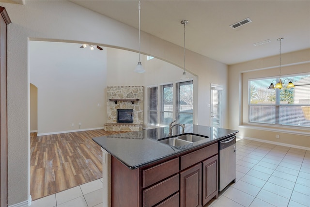 kitchen featuring dishwasher, ceiling fan with notable chandelier, sink, hanging light fixtures, and light tile patterned floors