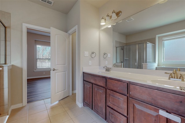 bathroom featuring tile patterned flooring, vanity, and walk in shower