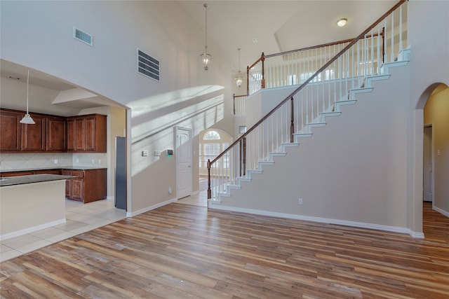 unfurnished living room featuring light hardwood / wood-style floors and a high ceiling