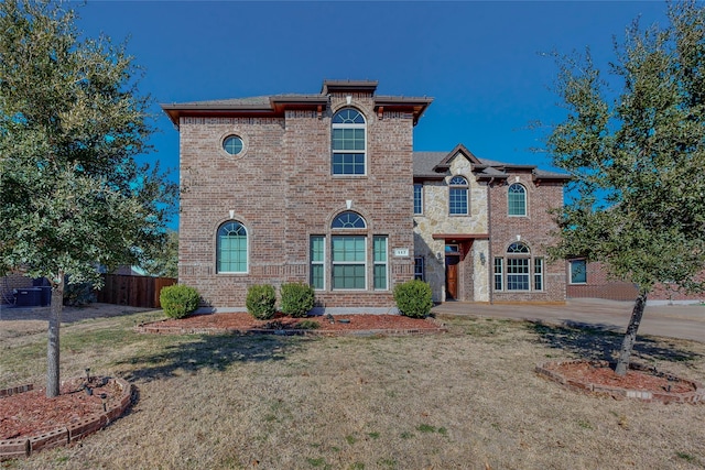 view of front of house featuring fence, a front lawn, and brick siding