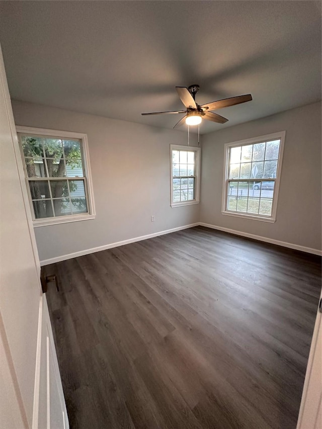 empty room with ceiling fan and dark hardwood / wood-style floors