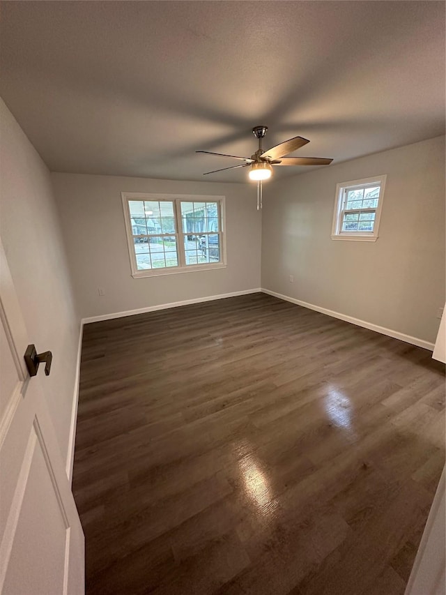 unfurnished room with dark hardwood / wood-style flooring, a wealth of natural light, and ceiling fan