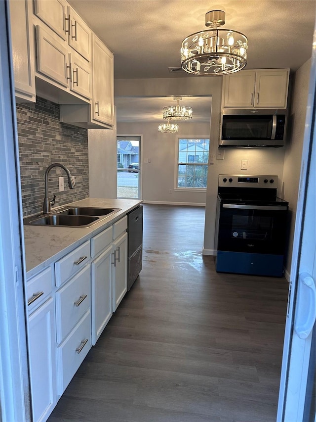 kitchen with electric range, white cabinetry, sink, and tasteful backsplash