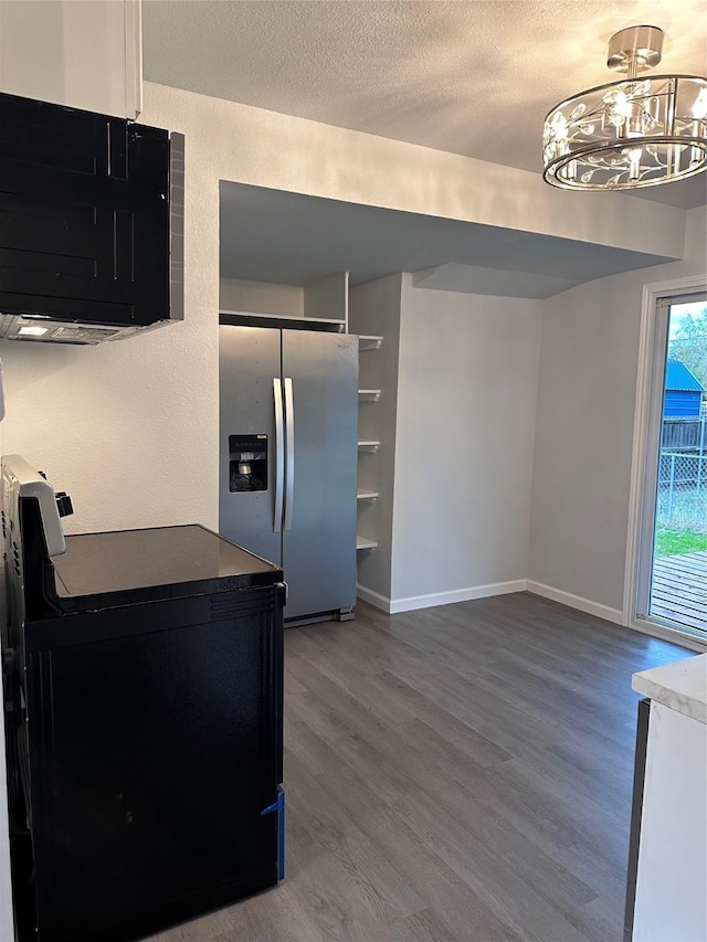 kitchen with a chandelier, stainless steel fridge, wood-type flooring, and a textured ceiling