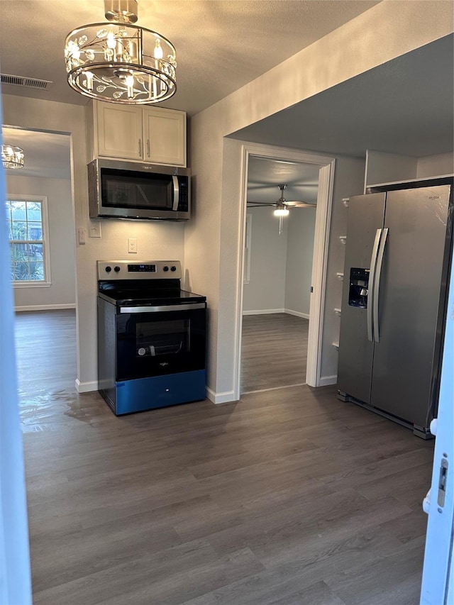 kitchen featuring white cabinets, ceiling fan with notable chandelier, a textured ceiling, appliances with stainless steel finishes, and wood-type flooring