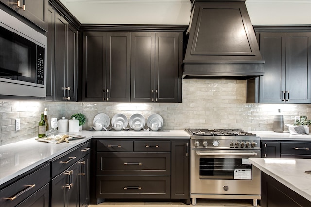 kitchen featuring decorative backsplash, light stone countertops, custom range hood, and stainless steel appliances