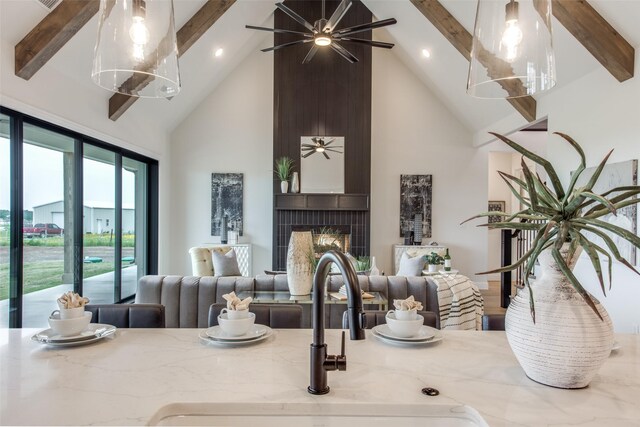 kitchen featuring light stone countertops, decorative light fixtures, a fireplace, and sink